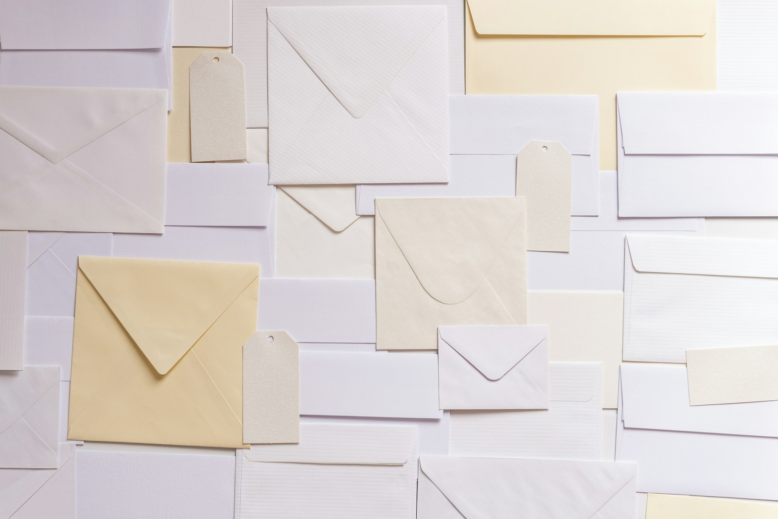 Plain white and cream envelopes and blank paper tags laid flat, seen from above